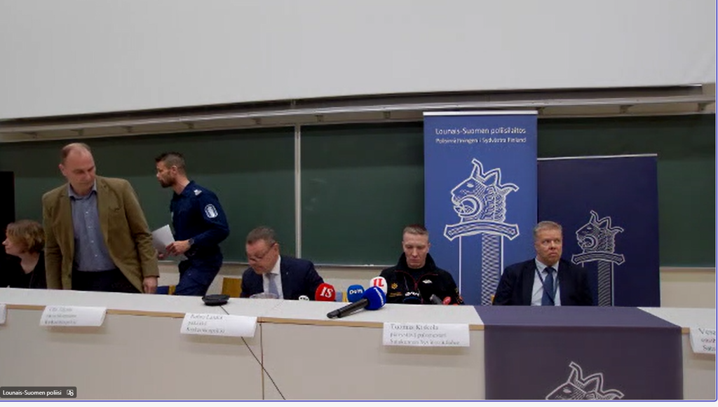 Tiedotustilaisuuteen osallistuneet viranomaiset asettuivat paikoilleen. Kuvassa OTKES:n viestintäpäällikkö Tiina Biber, ensihoidon toimintaa johtanut lääkäri Vesa Lund, Lounais-Suomen poliisin komisaario Antti Alitalo, tilaisuuden johtaja Robi Landet, Satakunnan pelastuslaitoksen Tuomas Kiskola sekä keskusrikospoliisin rikosylikomisaario Olli Töyräs.